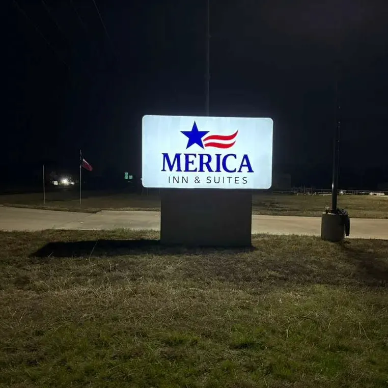 Merica Inn and Suites illuminated monument cabinet glowing at night